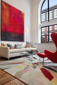 Red art, chair and in a rug, in a modern setting.