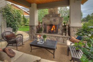A covered patio with a stone fireplace for cozy gatherings