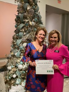 Carmen Dick and Chocky Burks with the elegant tree sponsored by Corcoran Premier Realty.