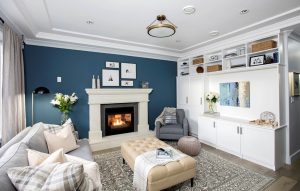 This design utilizes molding to create a focal point that draws your attention to the accent wall and fireplace, which perfectly complements the design aesthetic of the built-ins on the adjacent wall.