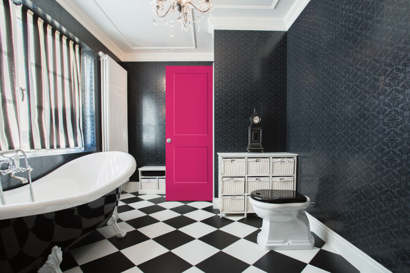 The black wallpaper, checkered floors, and white crown molding make for an exceptional bathroom design.