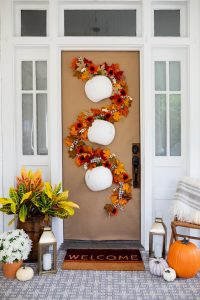 Fall foliage flows around white pumpkins.