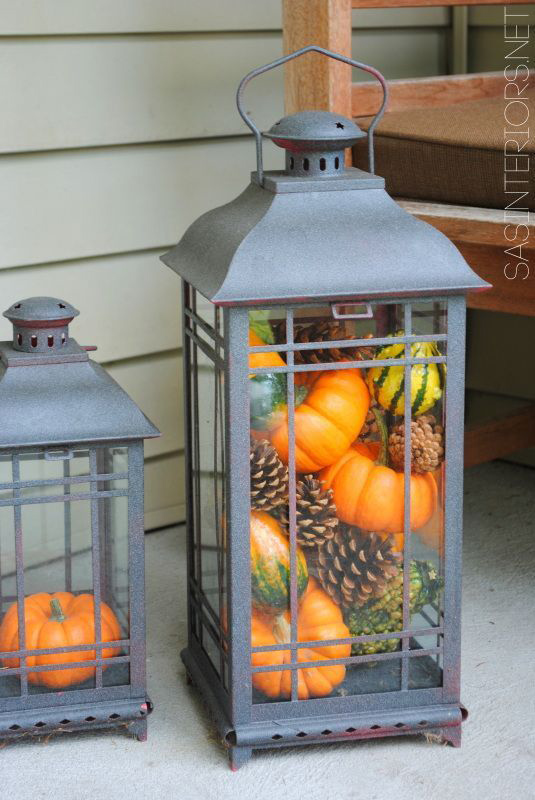 Pumpkin gourds in a lantern create a lovely fall presence.