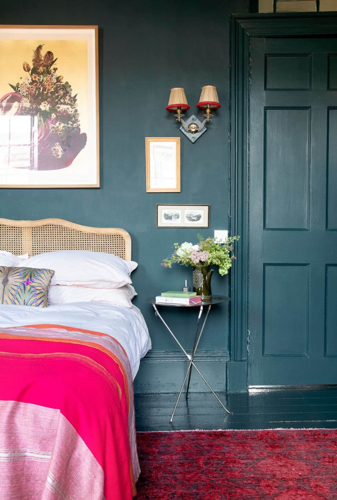 A pink throw and rug add playful pop to this moody bedroom.