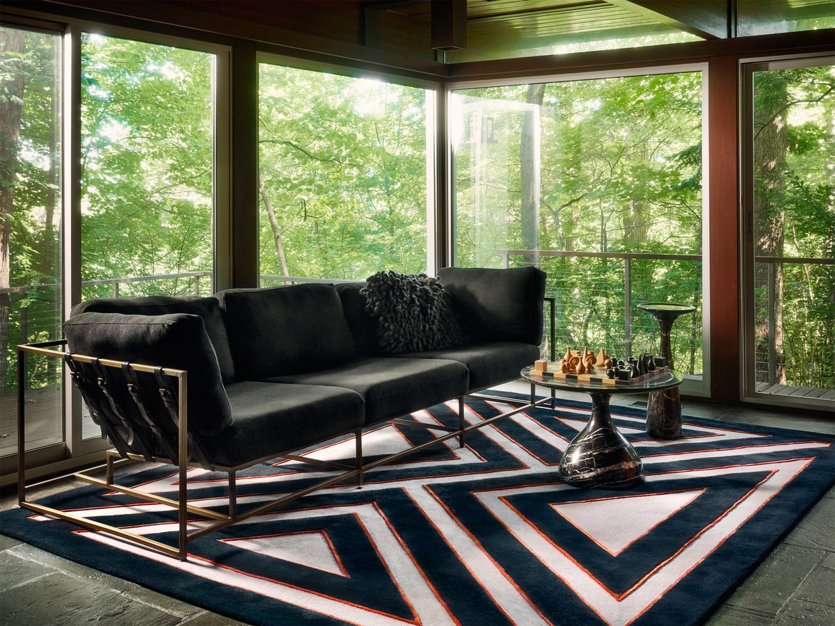 This wool-and-silk area rug takes center stage in a small sunroom.