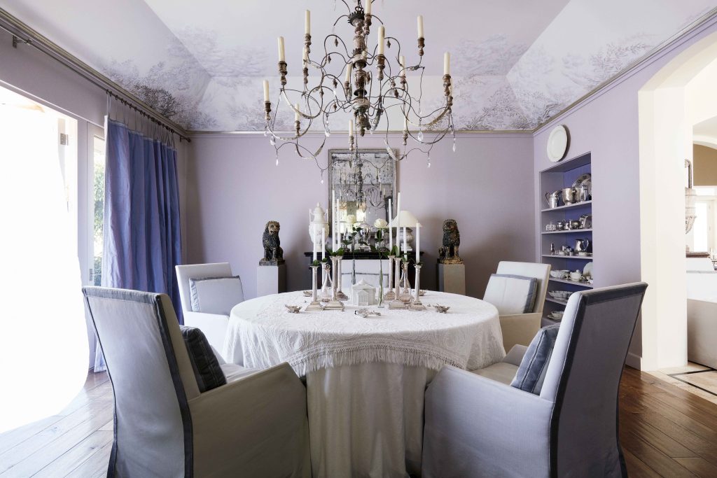 This dining room's painted ceiling is a half shade lighter (with some mural embellishments) than the wall color.