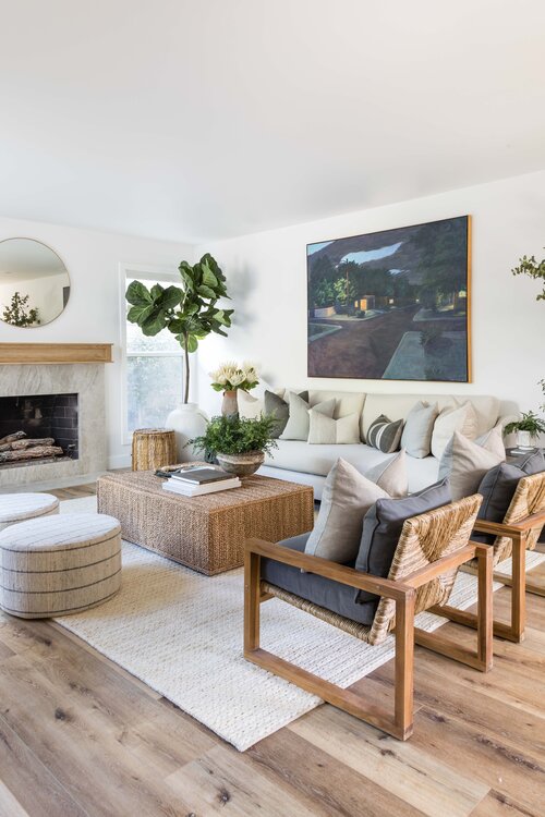This beautiful space incorporates woven textures through the armchairs, coffee table, rug, and ottomans.