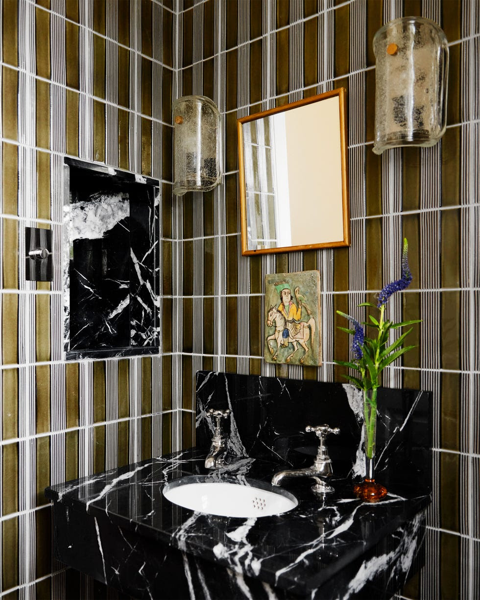 Elegant black-and-white marble transforms this guest bathroom into an opulent haven of luxury.